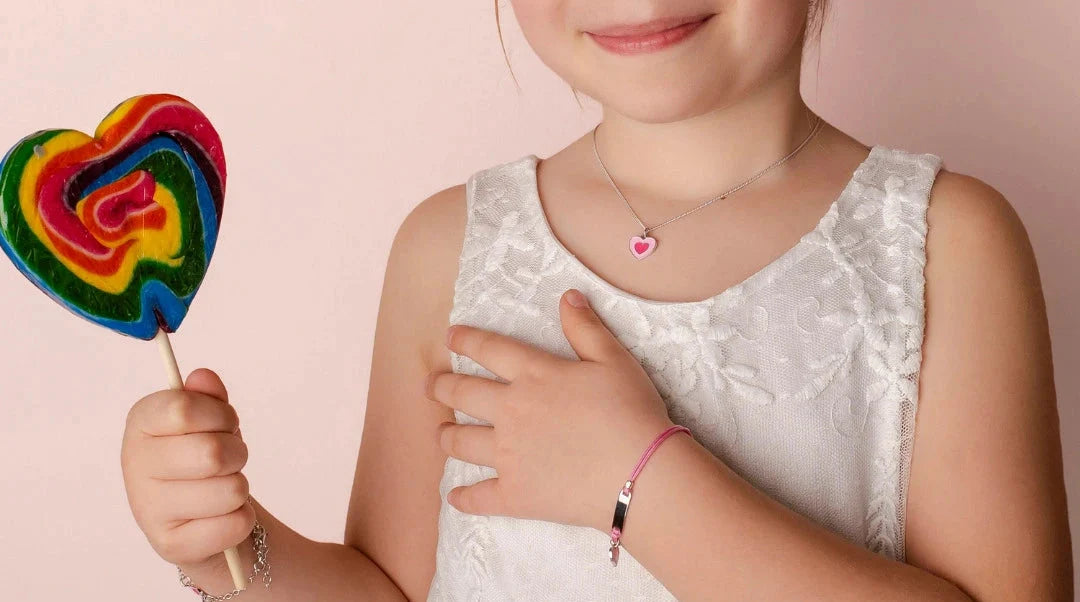 Bambina che indossa gioielli sakrami con in mano un lecca lecca 