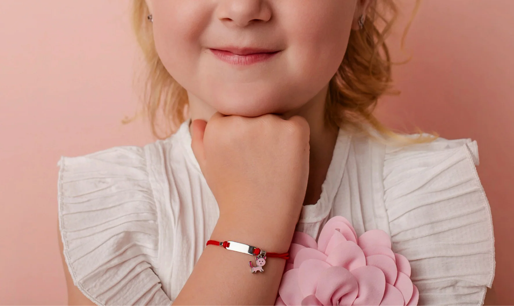Bambina sorridente con bracciale Sakrami Kids, ritratto dolce e luminoso della collezione bambini.