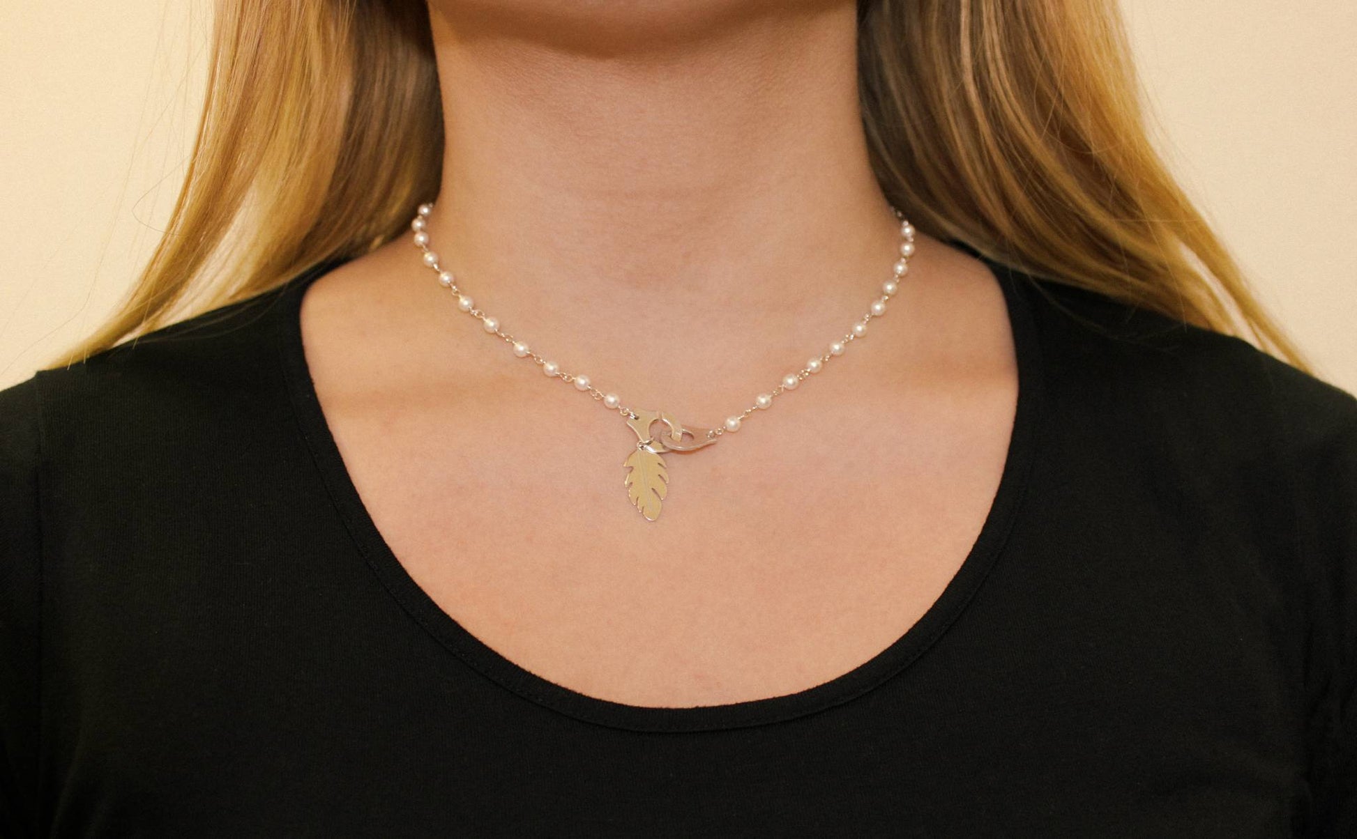 Perlenkette mit Handschellen und Blatt