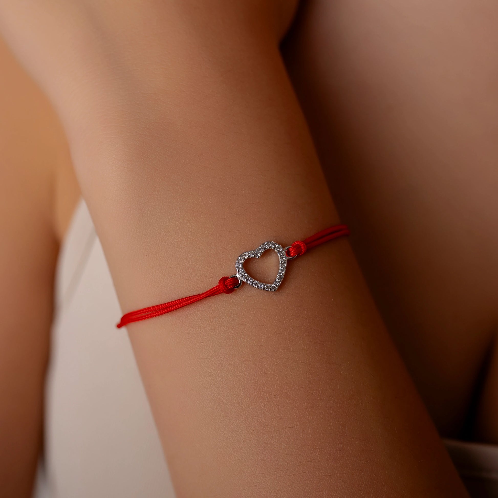 Silberarmband mit durchbrochenem Strassherz am Kordel