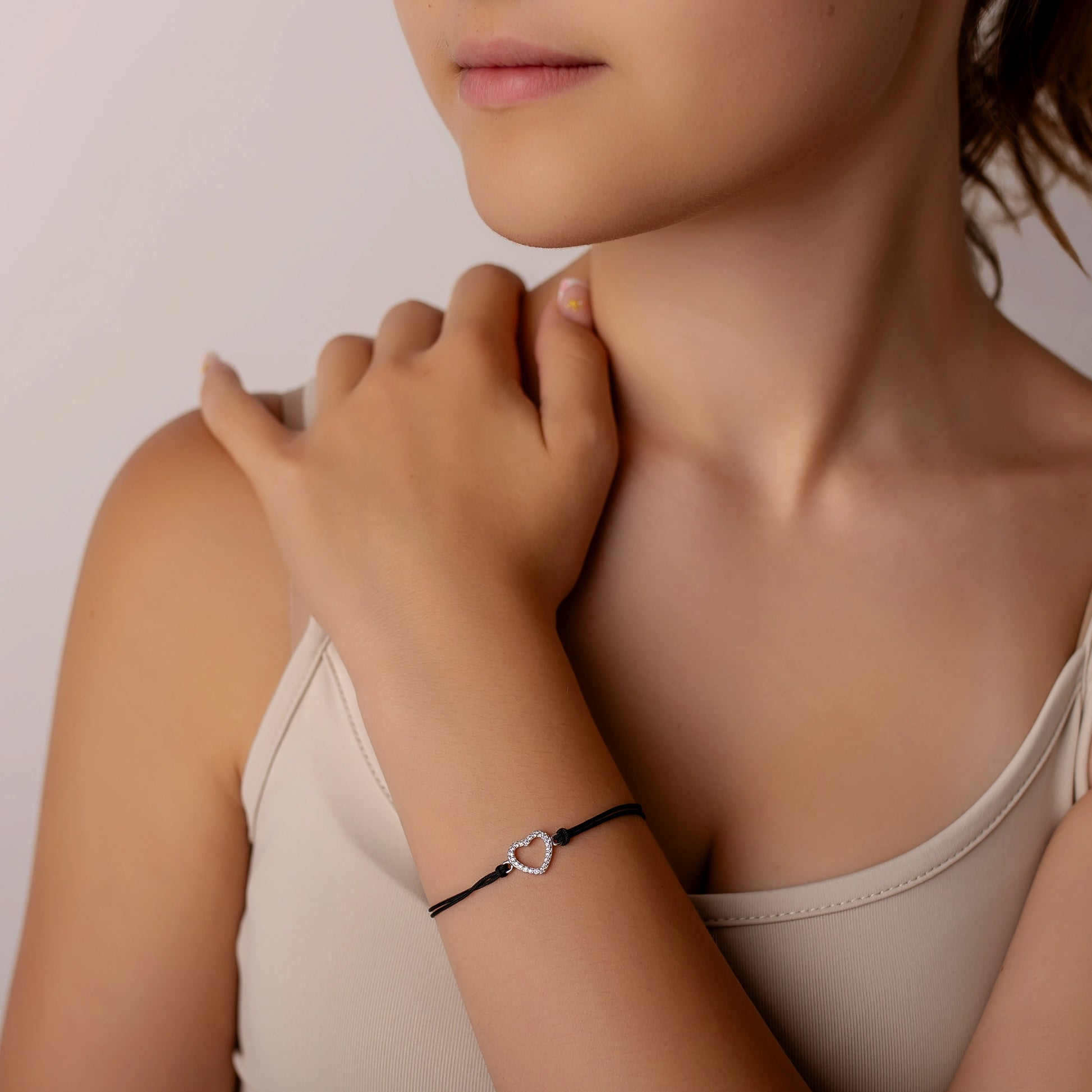 Silberarmband mit durchbrochenem Strassherz am Kordel