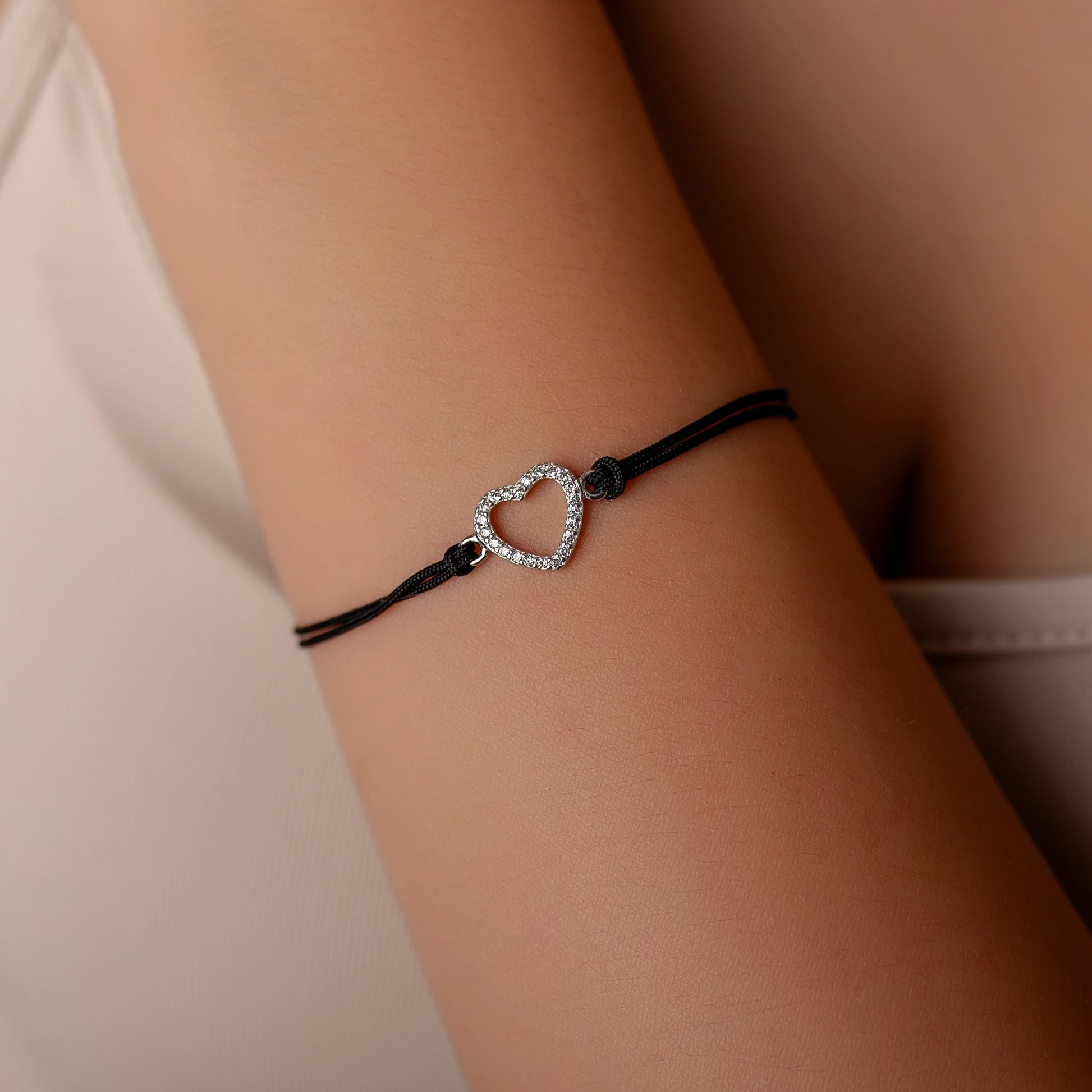 Silberarmband mit durchbrochenem Strassherz am Kordel