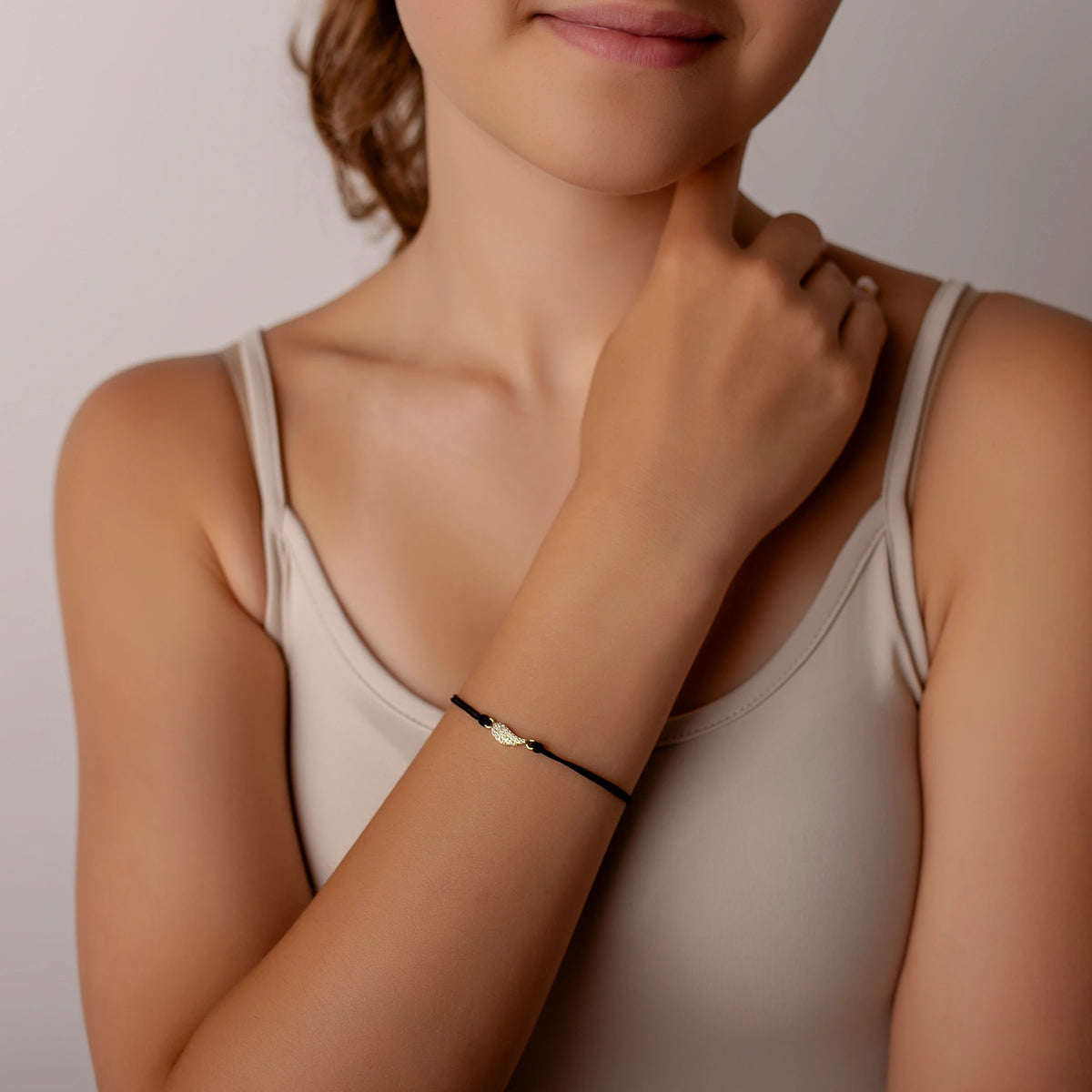 Pulsera de plata dorada con cordón y ala con strass pequeño