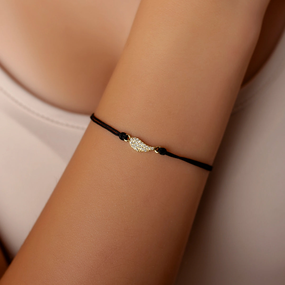 Pulsera de plata dorada con cordón y ala con strass pequeño