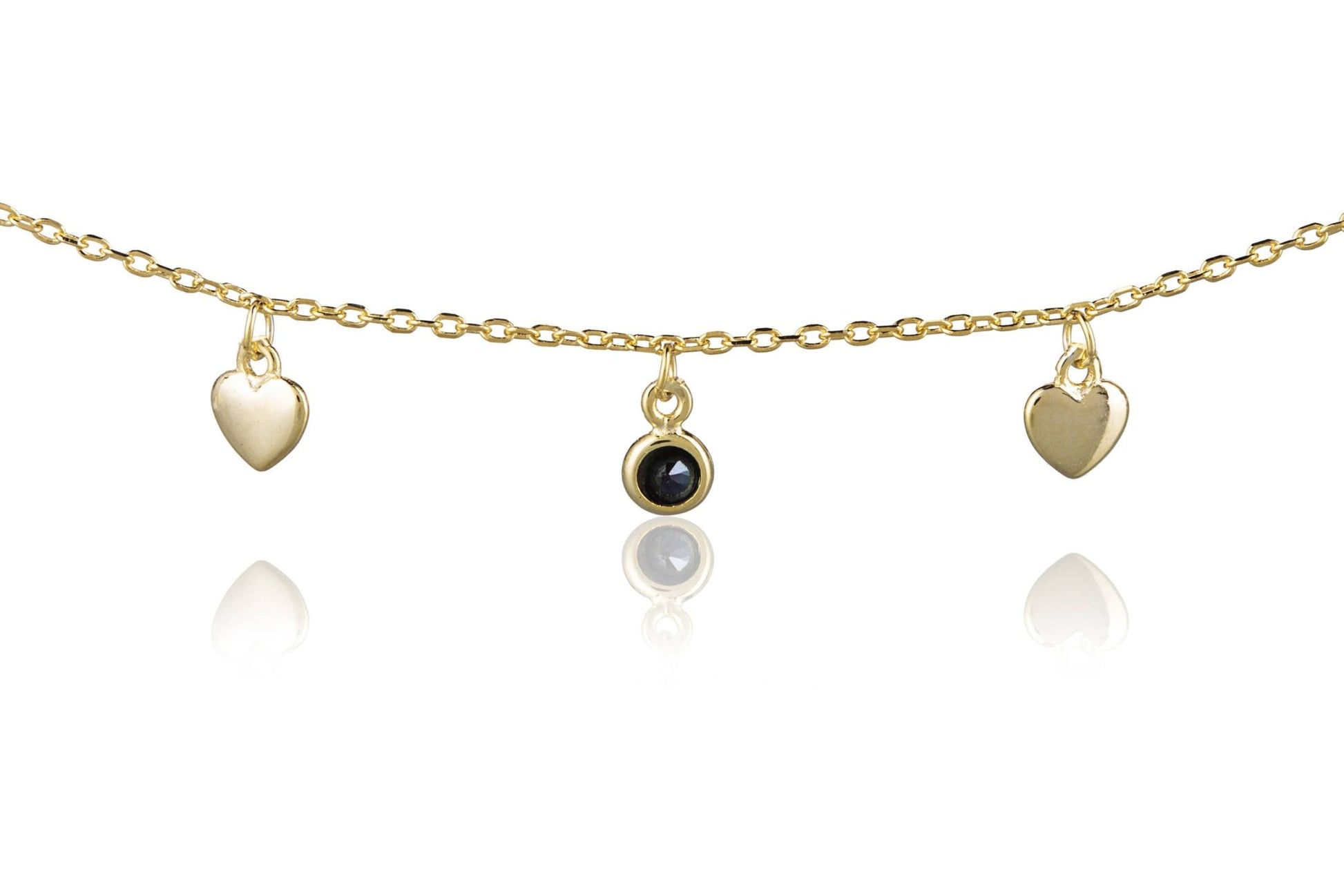 Pulsera de plata dorada con corazones y puntos de luz negros