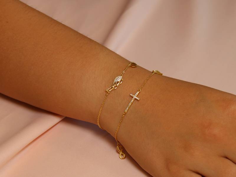 Pulsera de plata con colgante de ala y punto de luz rodiado