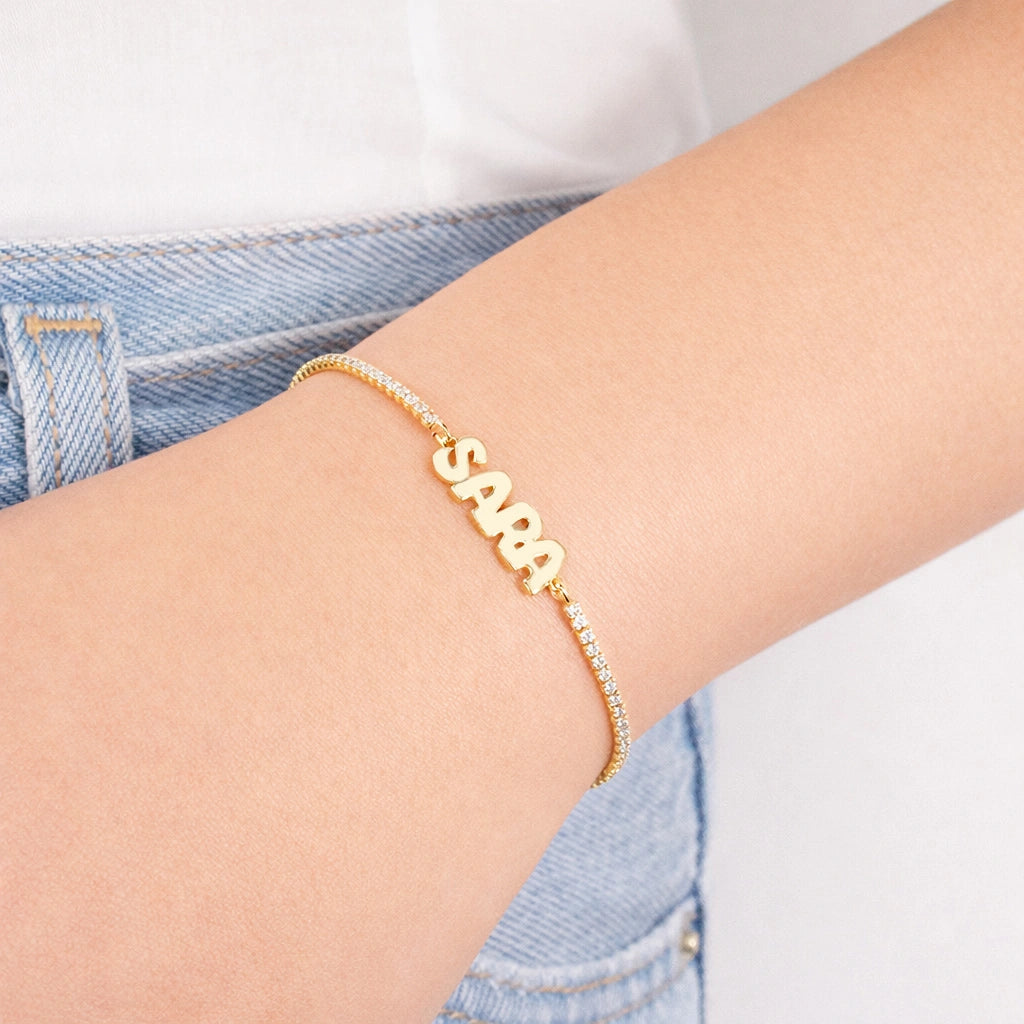 Pulsera tenis con nombre dorado en mayúsculas